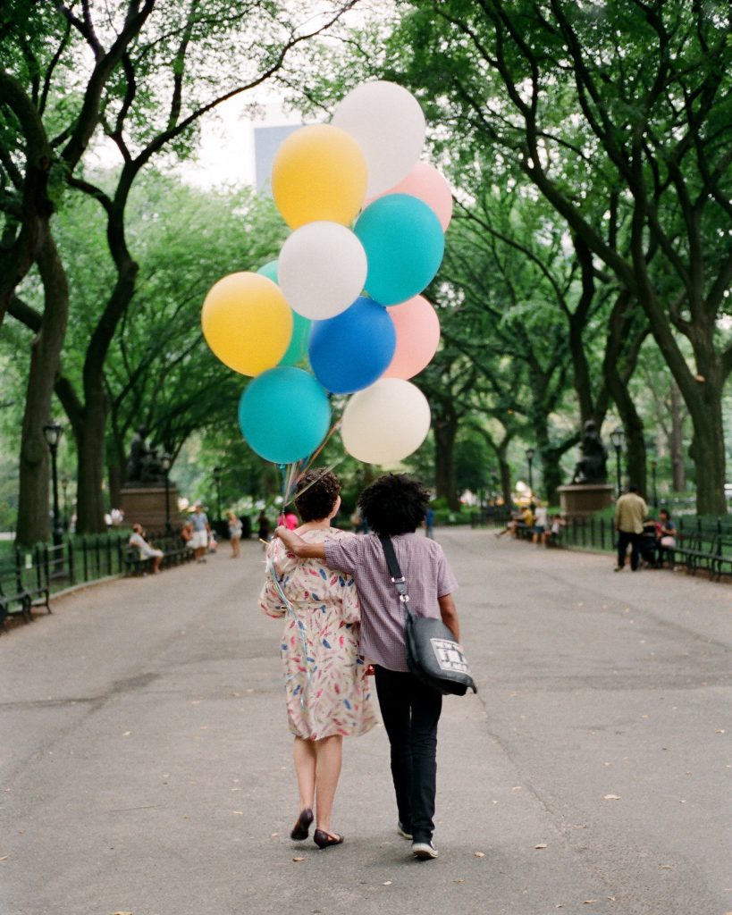 engaged couple walking arm in arm central park