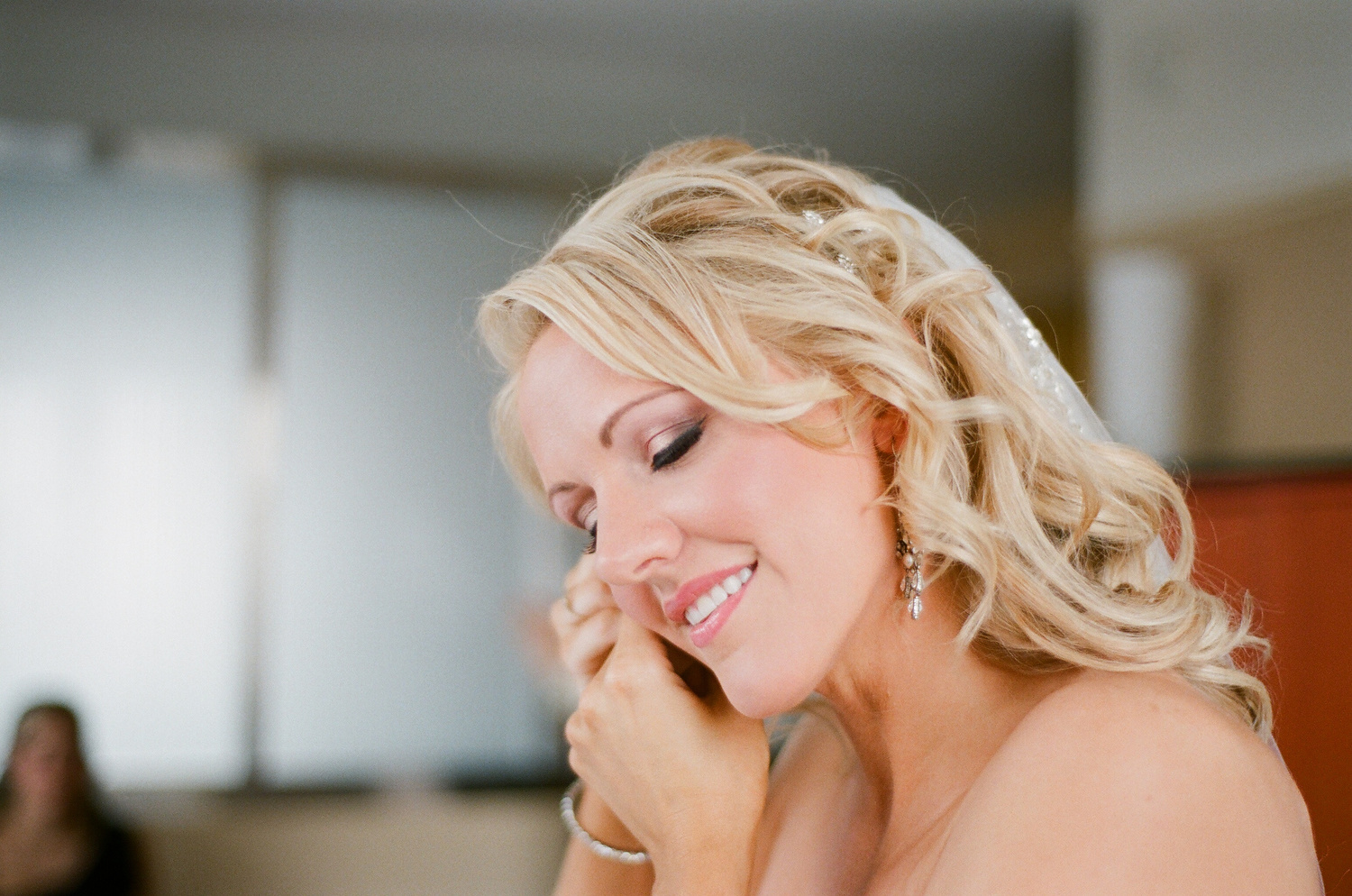 photos of bride putting on her earrings